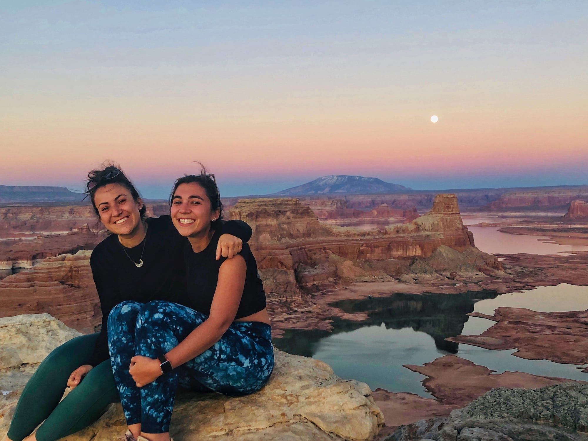 two girls sitting at alstrom point at sunset