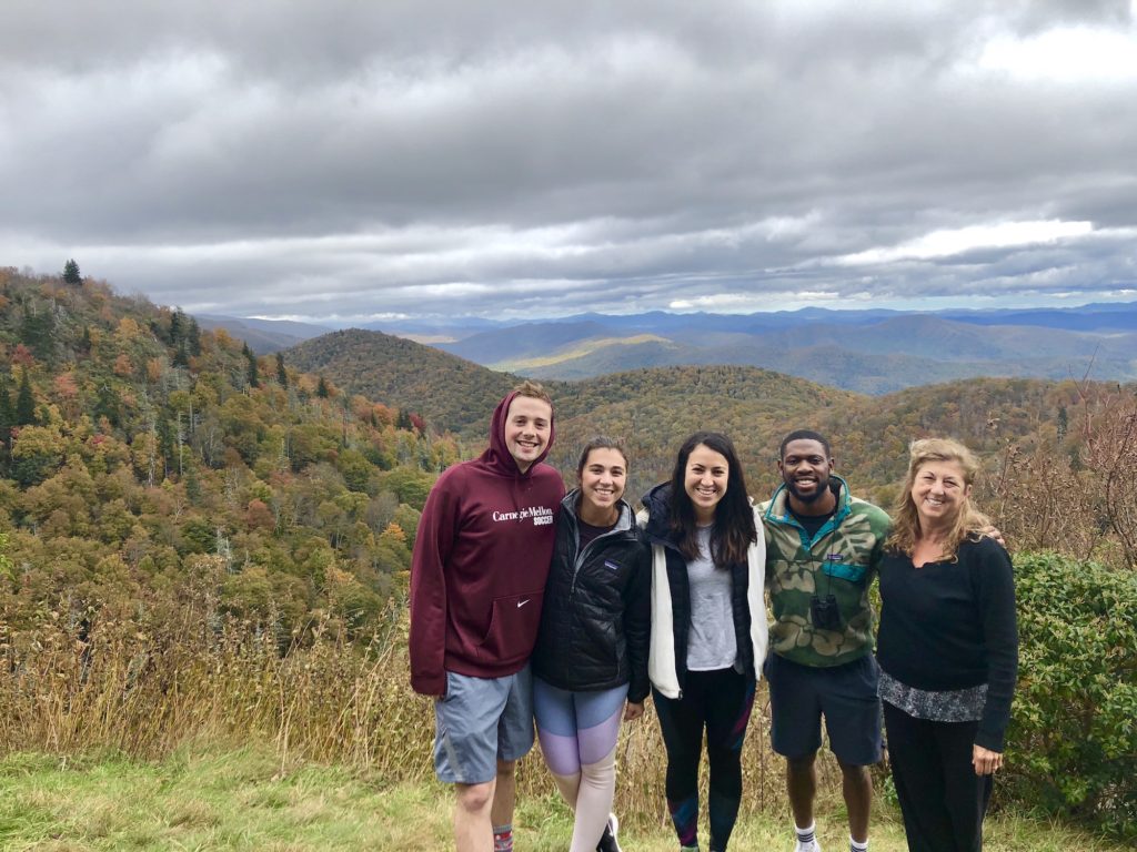 group of people in front of mountains on blue ridge parkway
