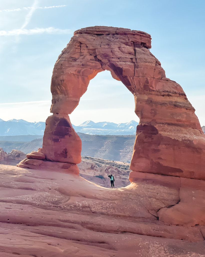 Girl standing under delicate Arch