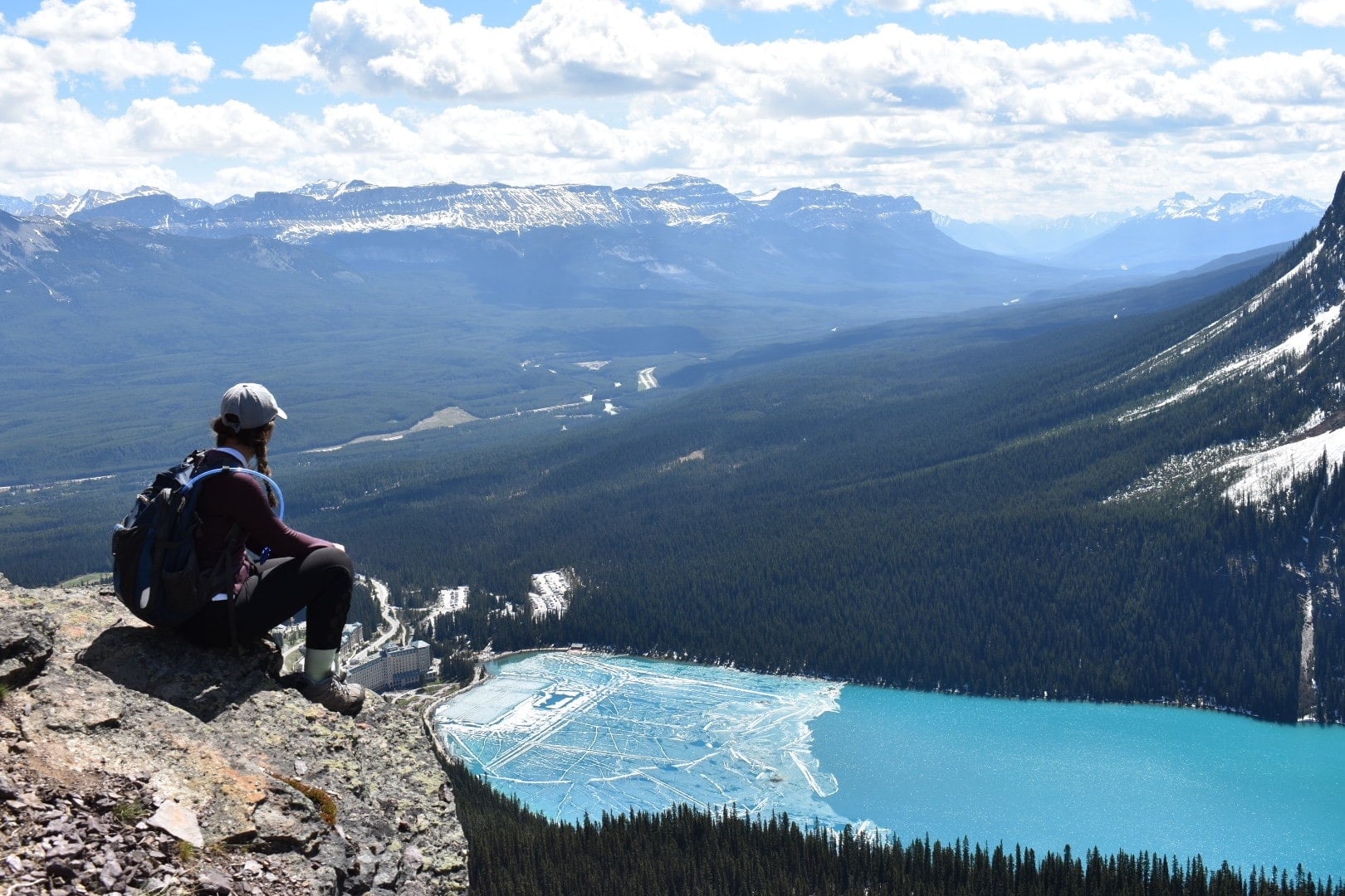 girl sitting over lake louise and fairmont chateau