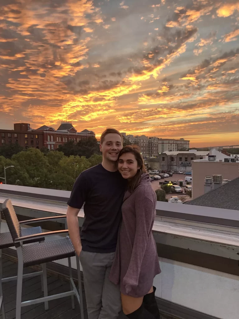 Couple enjoying a bright and vibrant sunset on a roof bar in Savannah