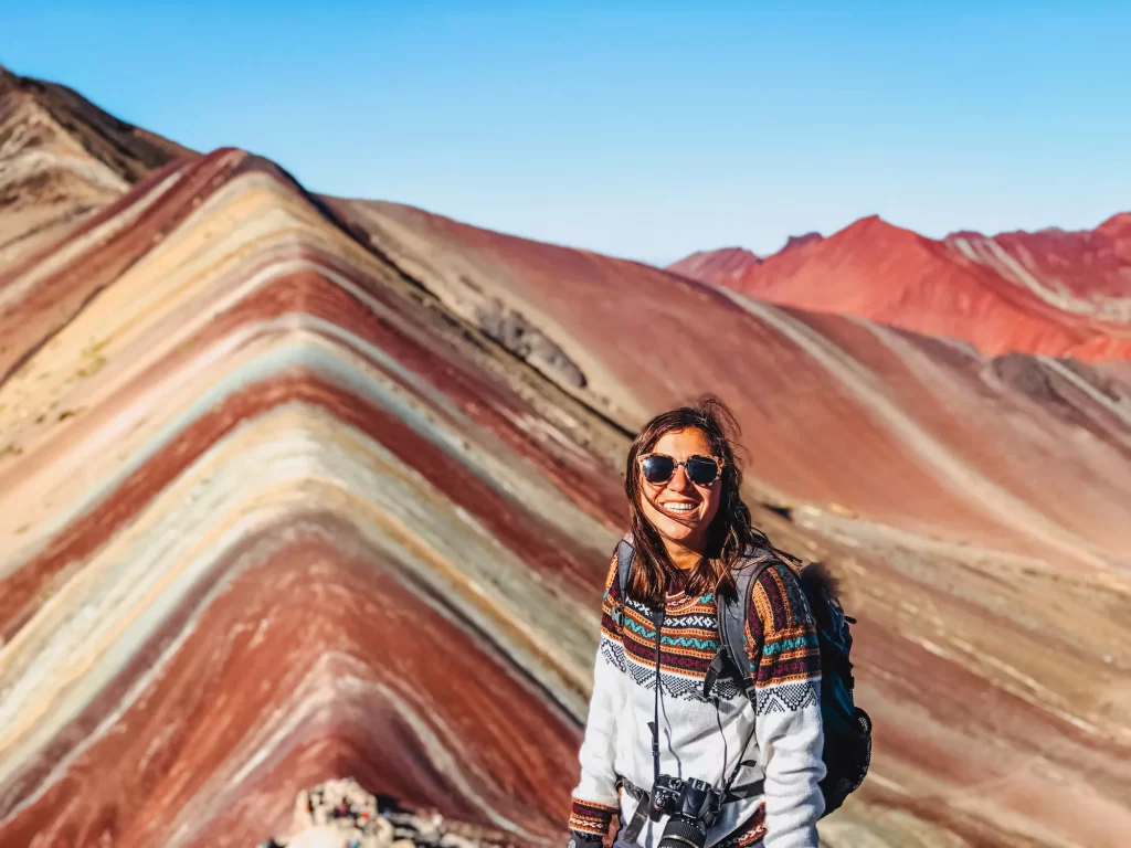 girl standing in front of rainbow mountain