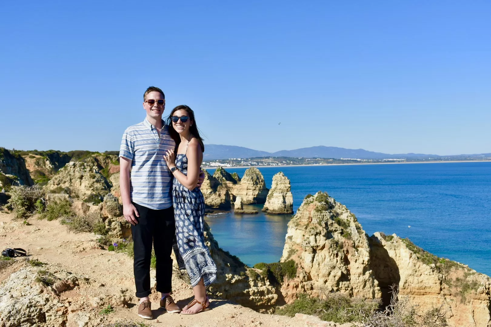 two people standing on the coast