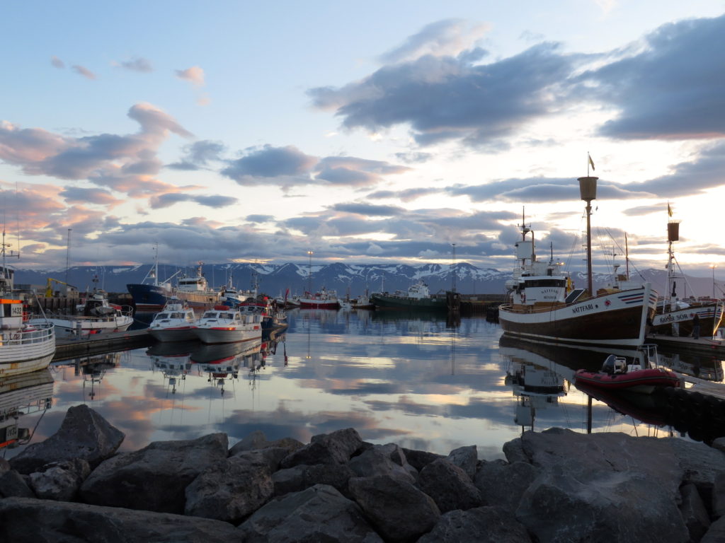 Husavik with sunrise over boats on the water