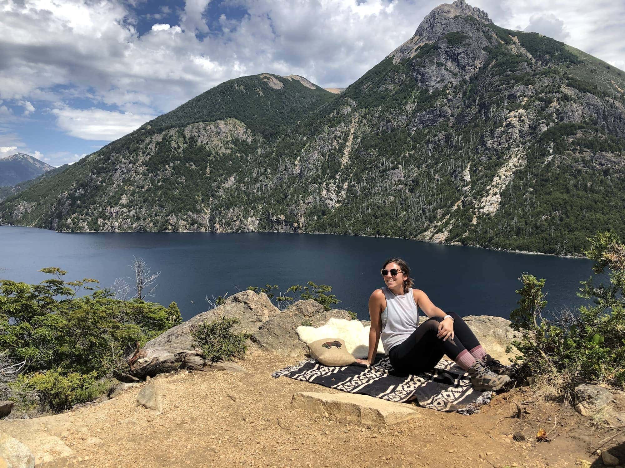 Girl sitting on a blanket with mountain in background