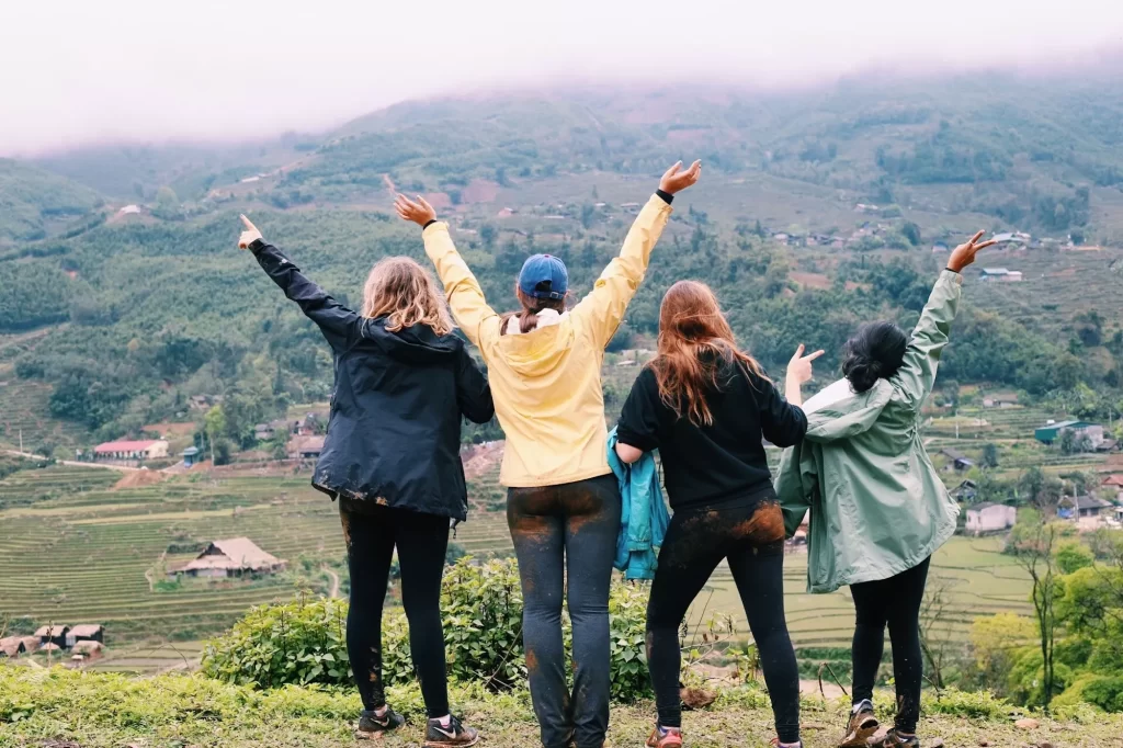 four girls standing looking out at sapa mountains with mud on their butts