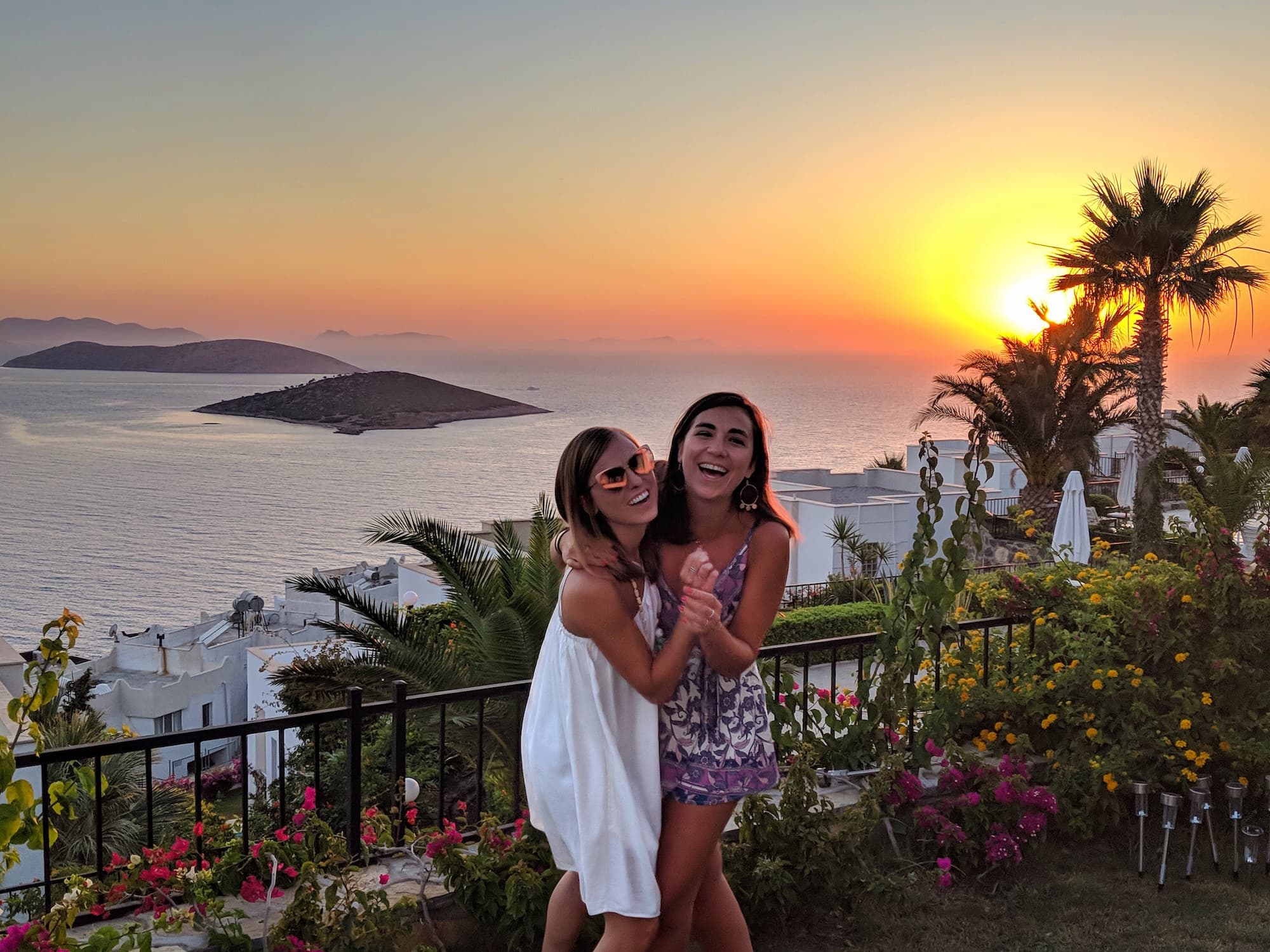 Reasons to go to Bodrum, Turkey Cover photo: Two girls laughing as the sunsets over cliffs