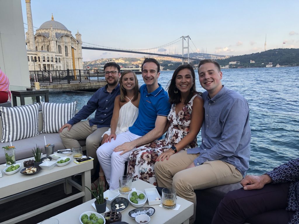 Five friends sit in front of the Bosphorus at dinner