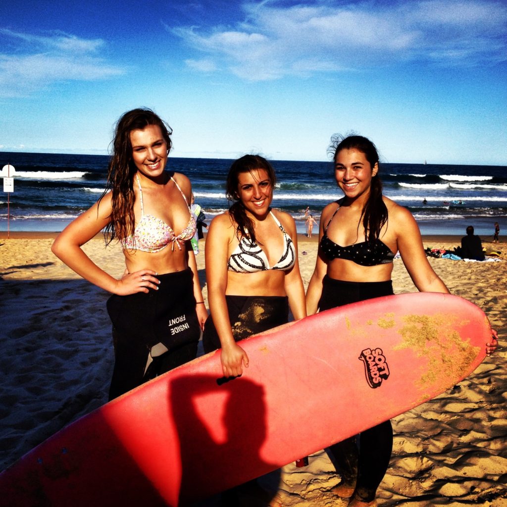Three girls with surf board