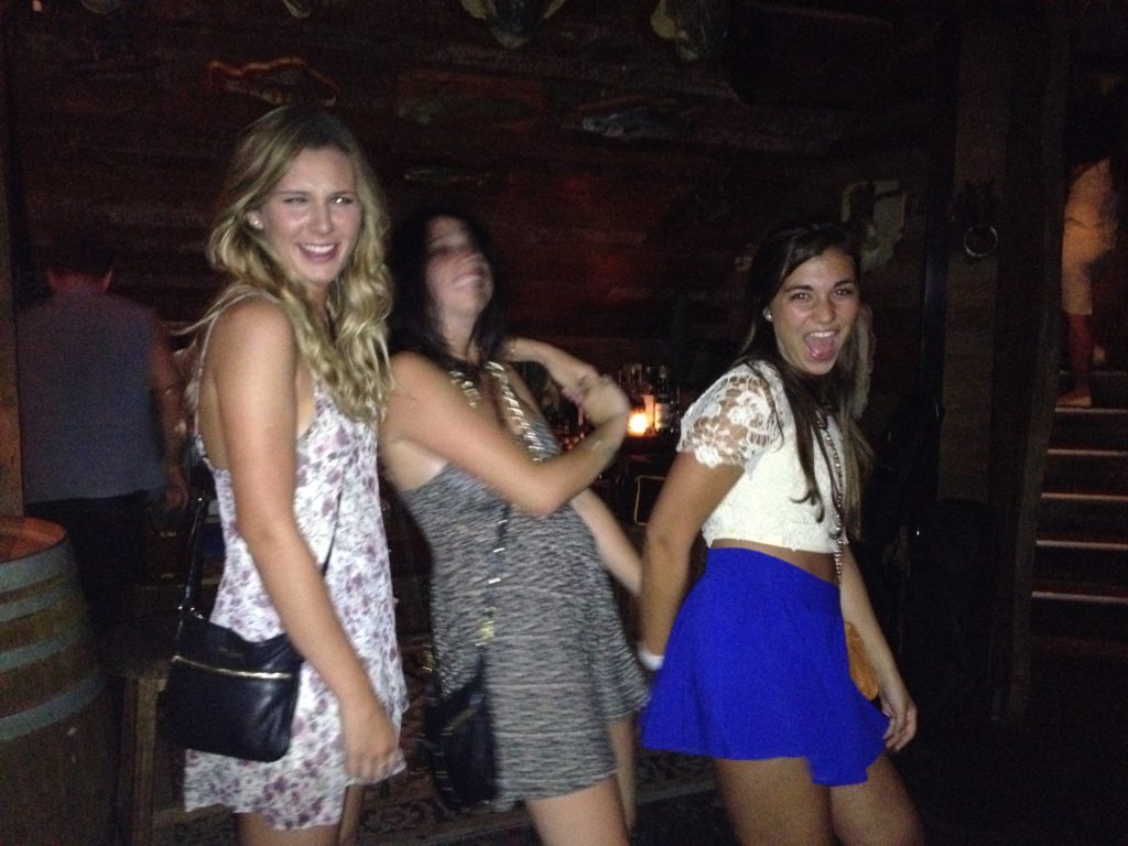 Three girls dancing at bar