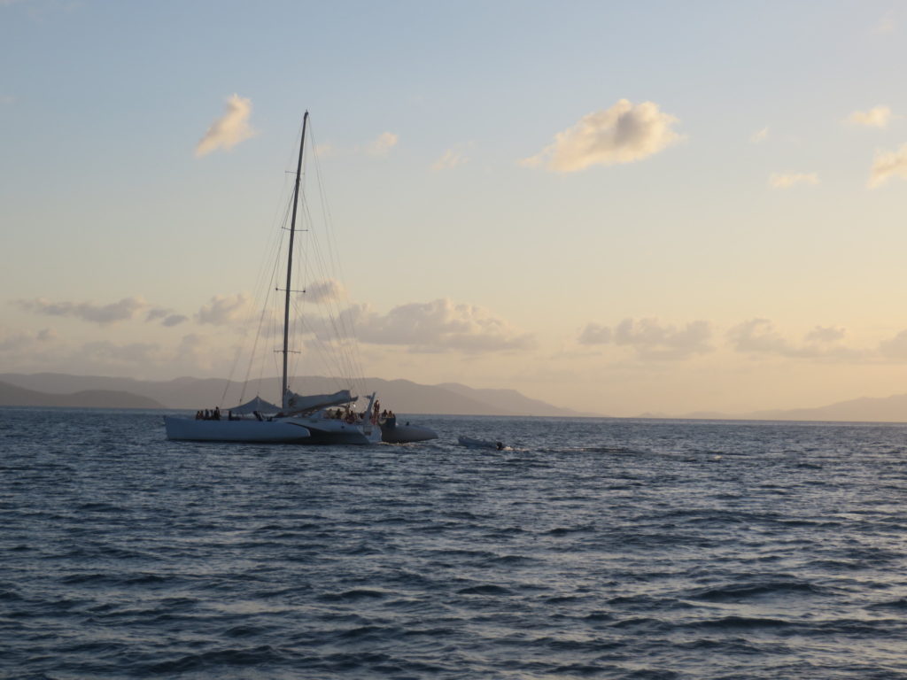 Sailing boat on the ocean with sunset behind