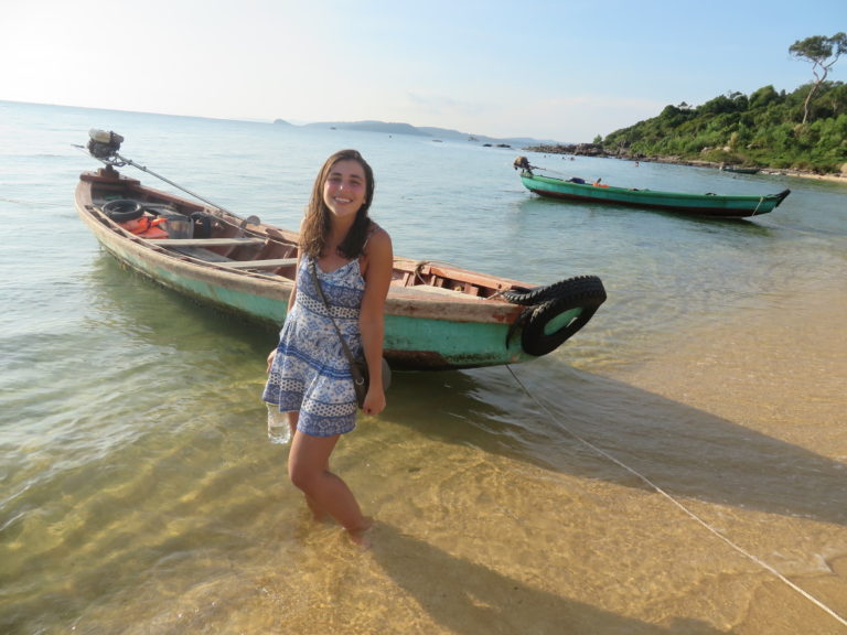 Female standing in water with boats behind