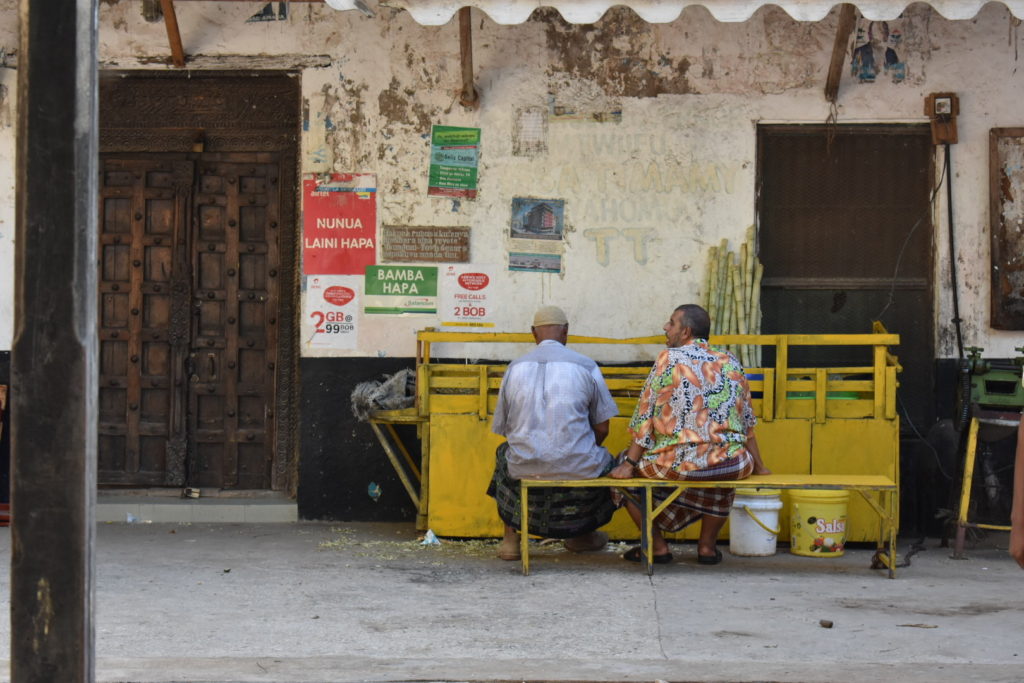 two men sitting an dchatting in Lamu