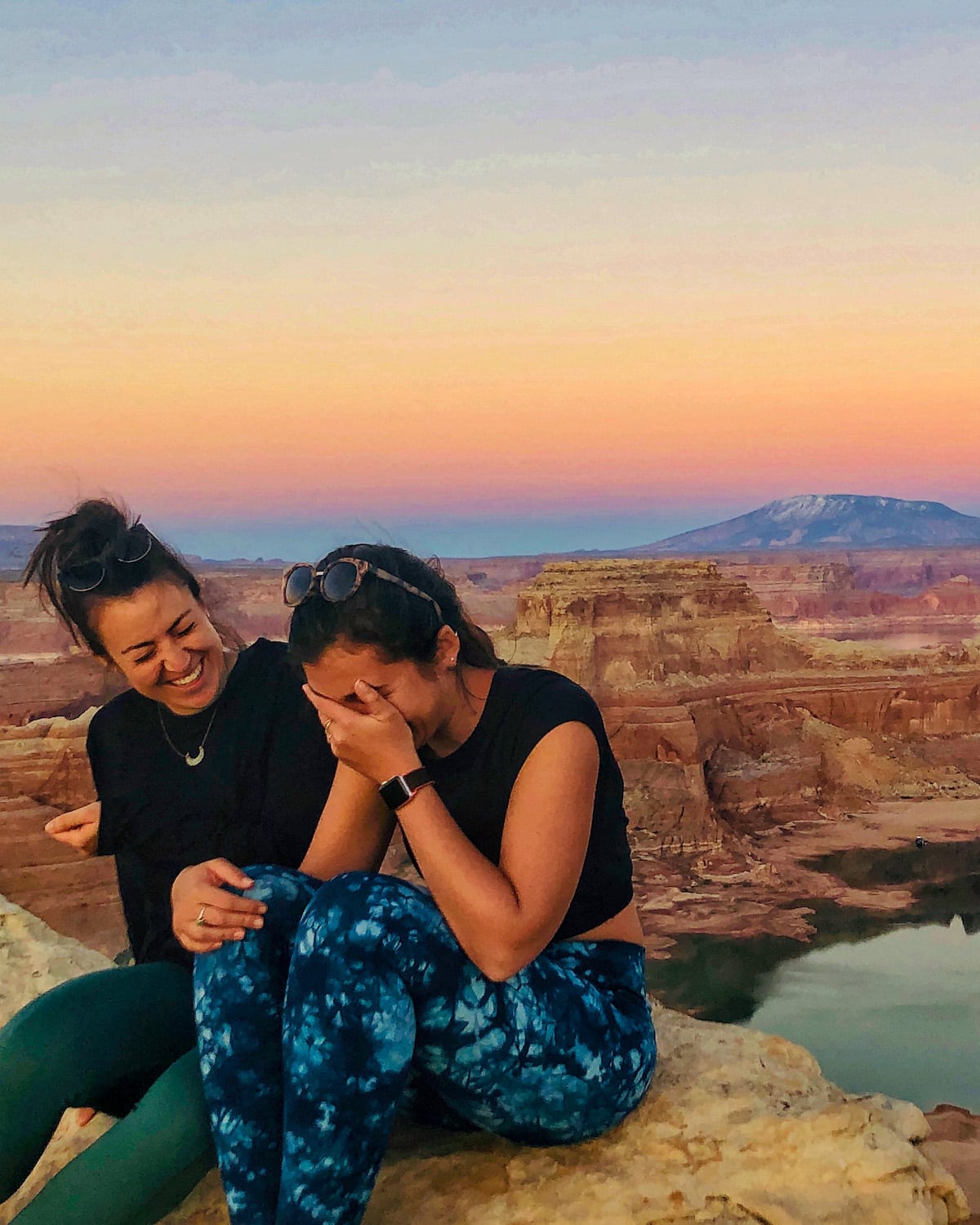 girls laughing with sunset behind them