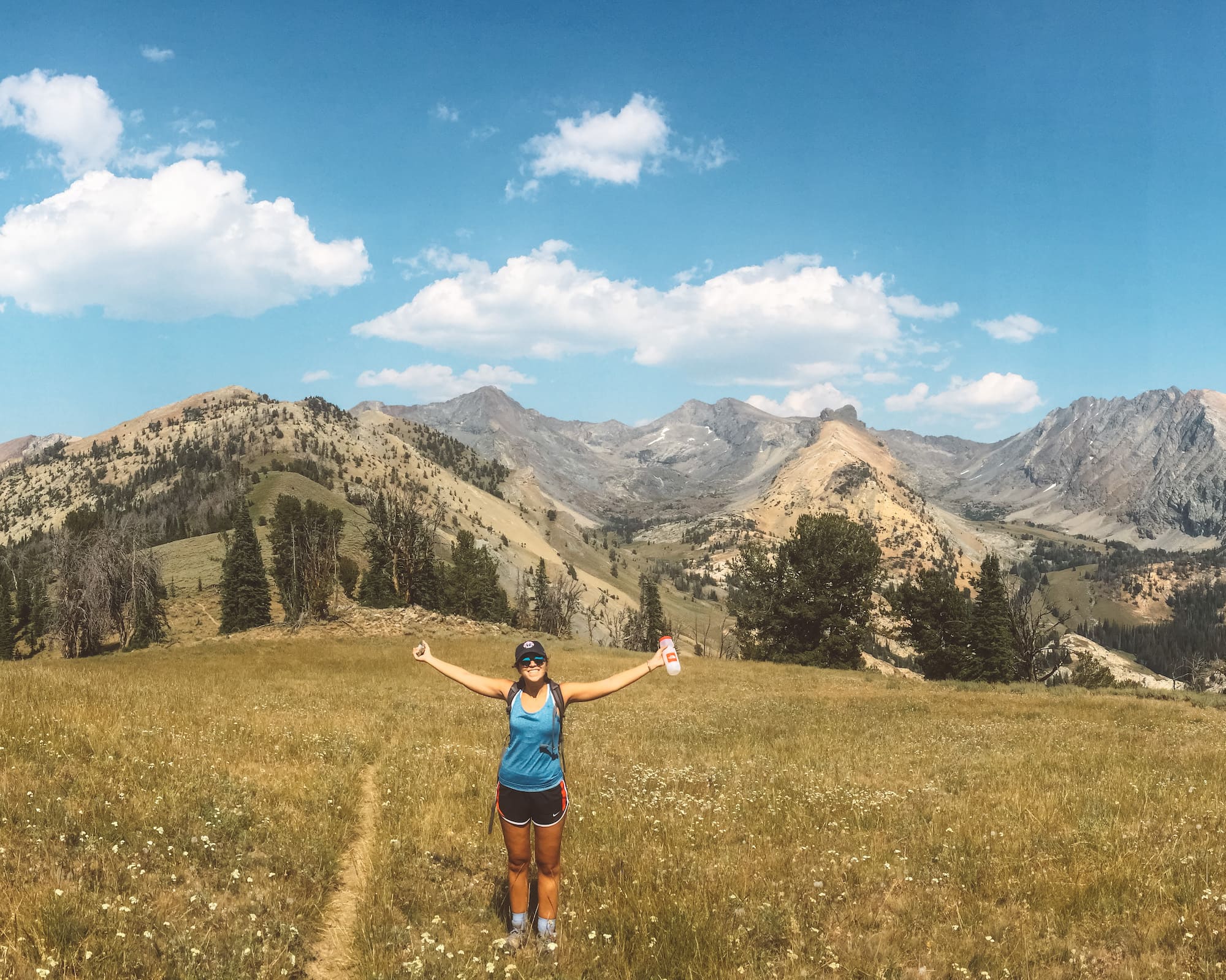Sun Valley Hikes Cover, girl with arms out standing on top of Pioneer Cabin trail mountain top