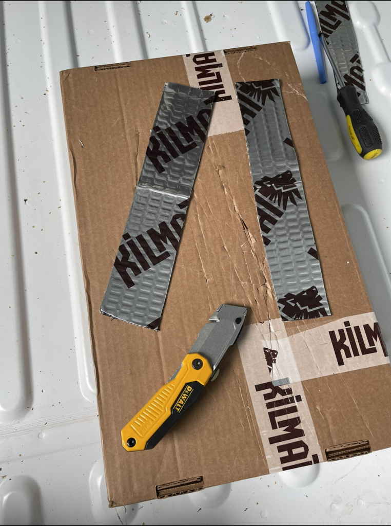 exacto knife and cardboard with cuts in it