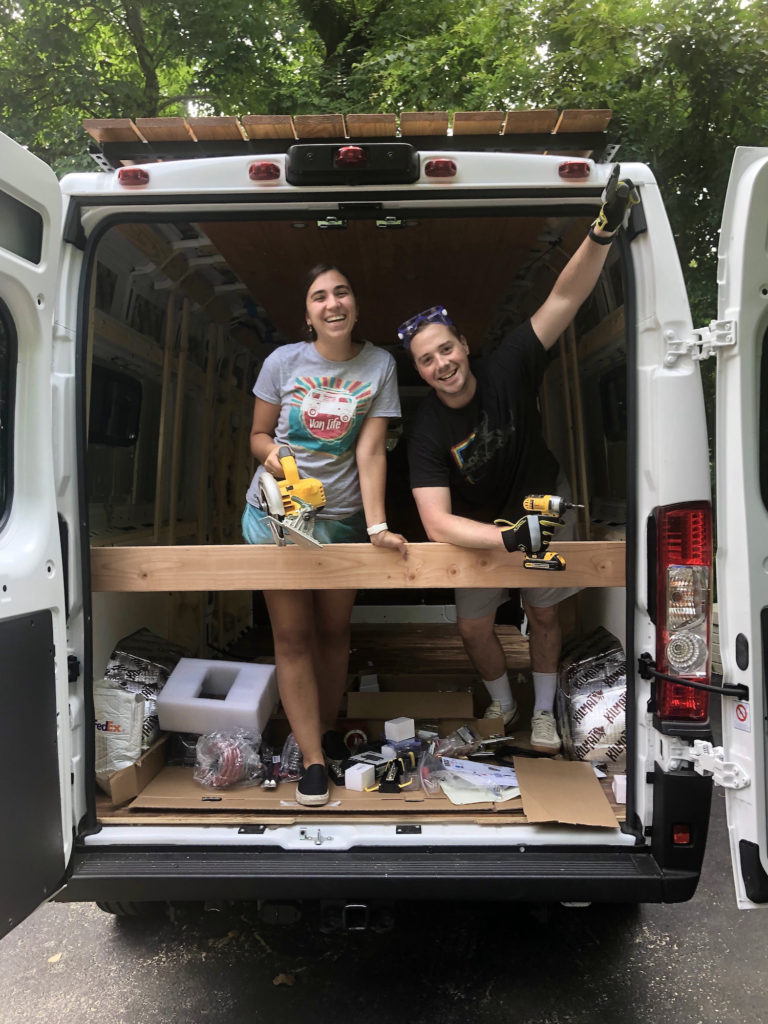 Frame a Van cover: Lita and Dylan stand in front of framed van with tools in hand
