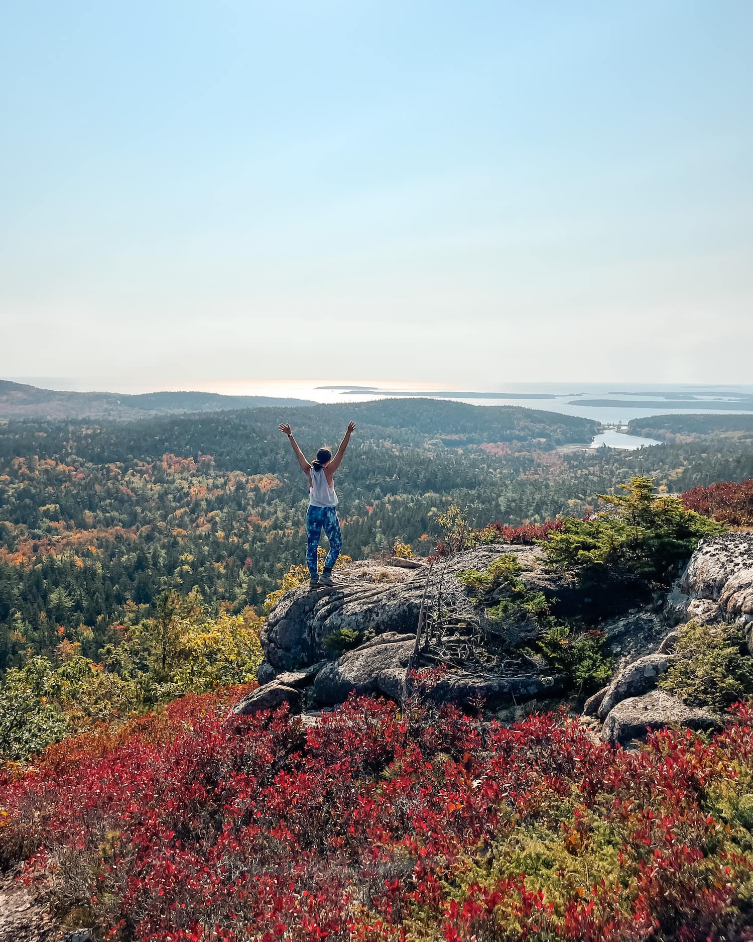 I'm standing on top of Mountains with hands up looking out on cliffs; Best Hikes in Acadia cover