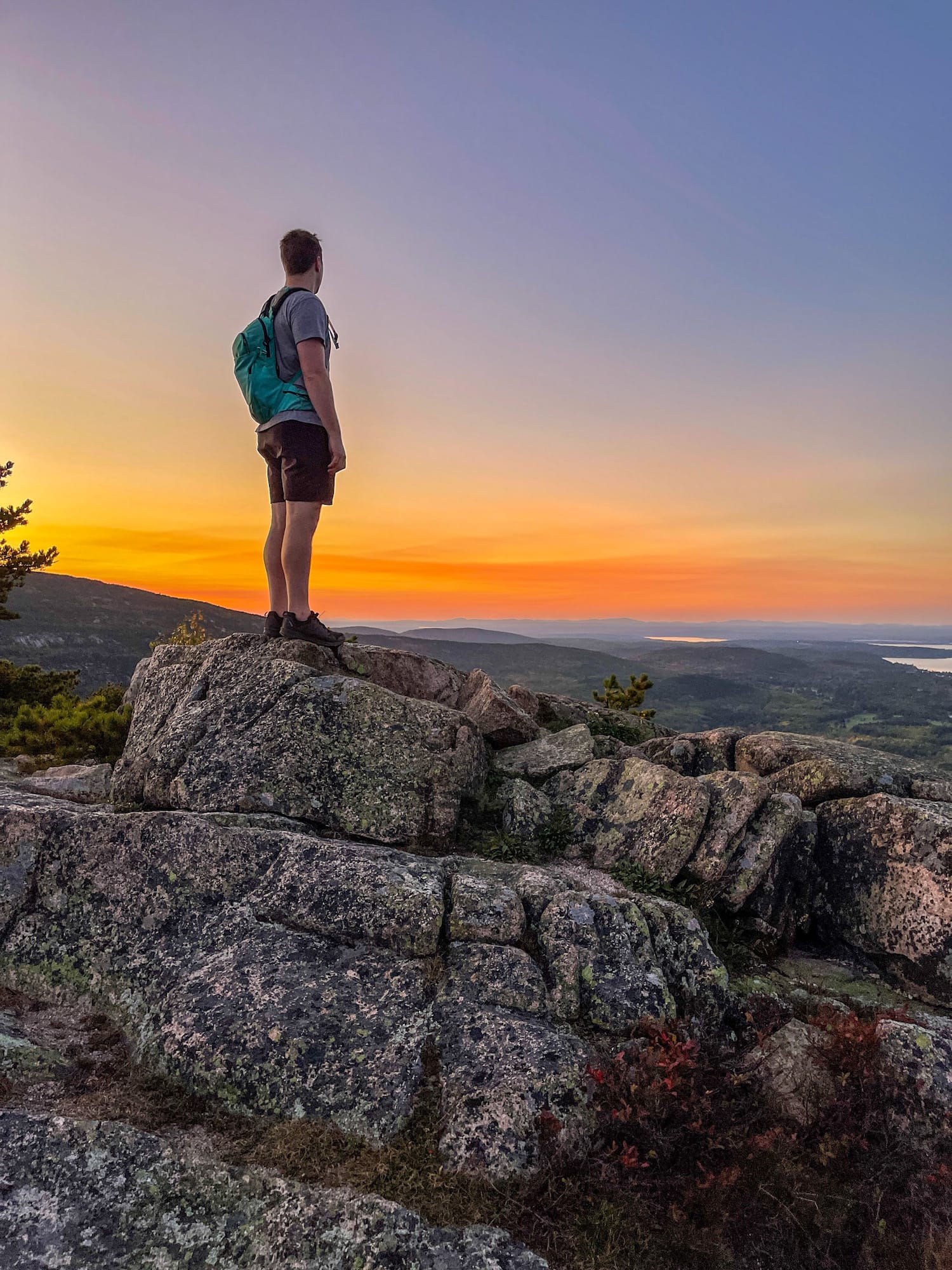 Dylan on top of mountain with sunset all over