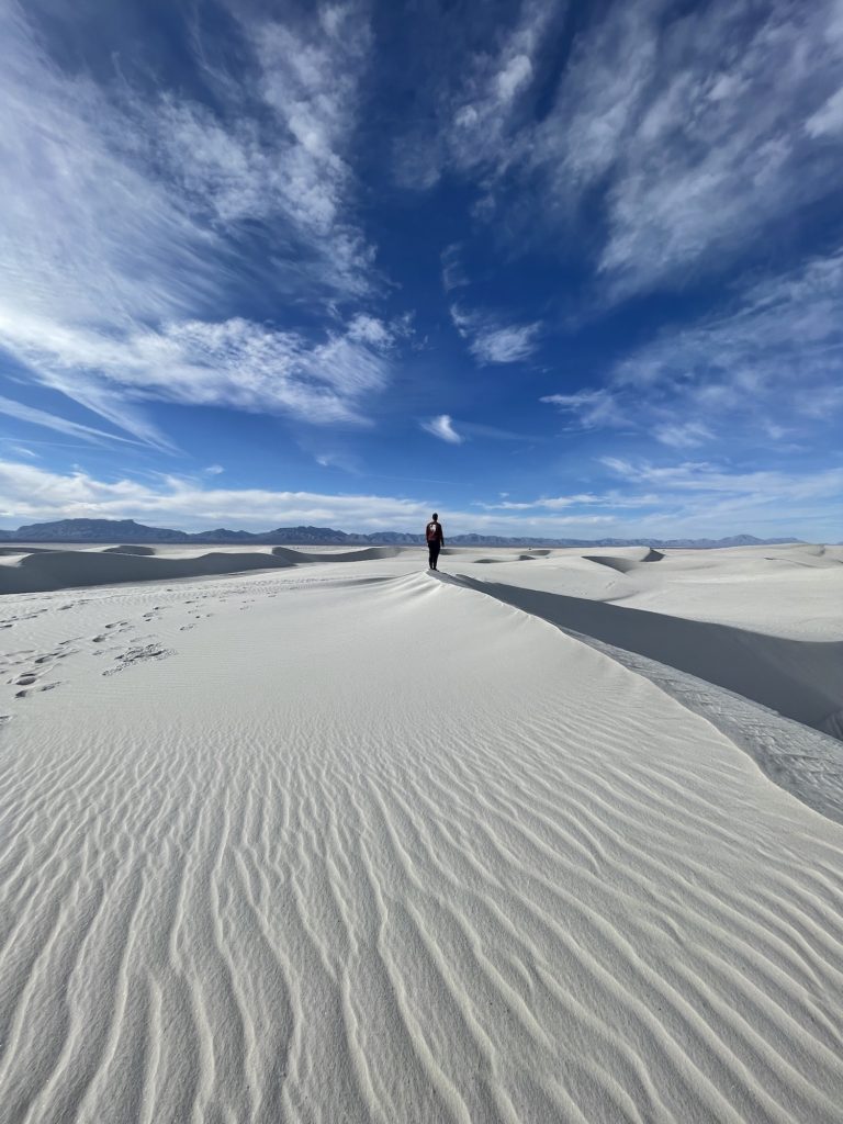 Dylan standing atop a dune in white sands