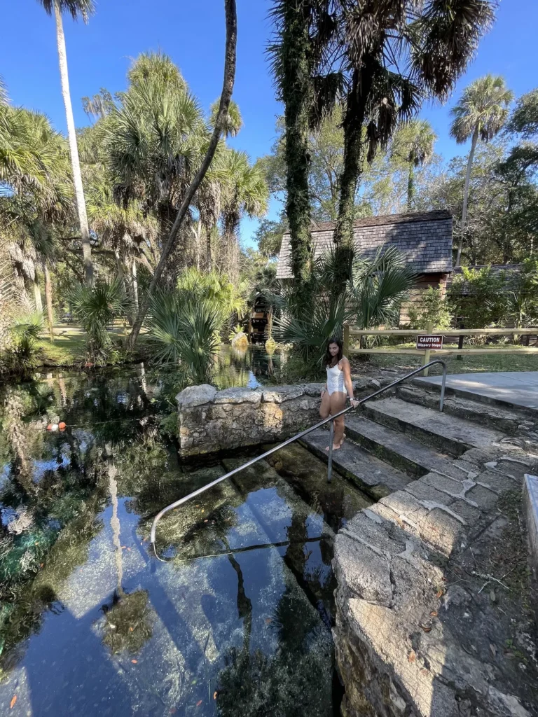 woman walking into Juniper springs with mill behind