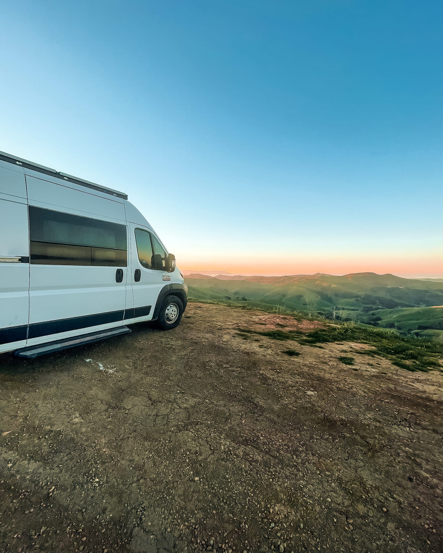 Van over rolling hills with sunrise in back