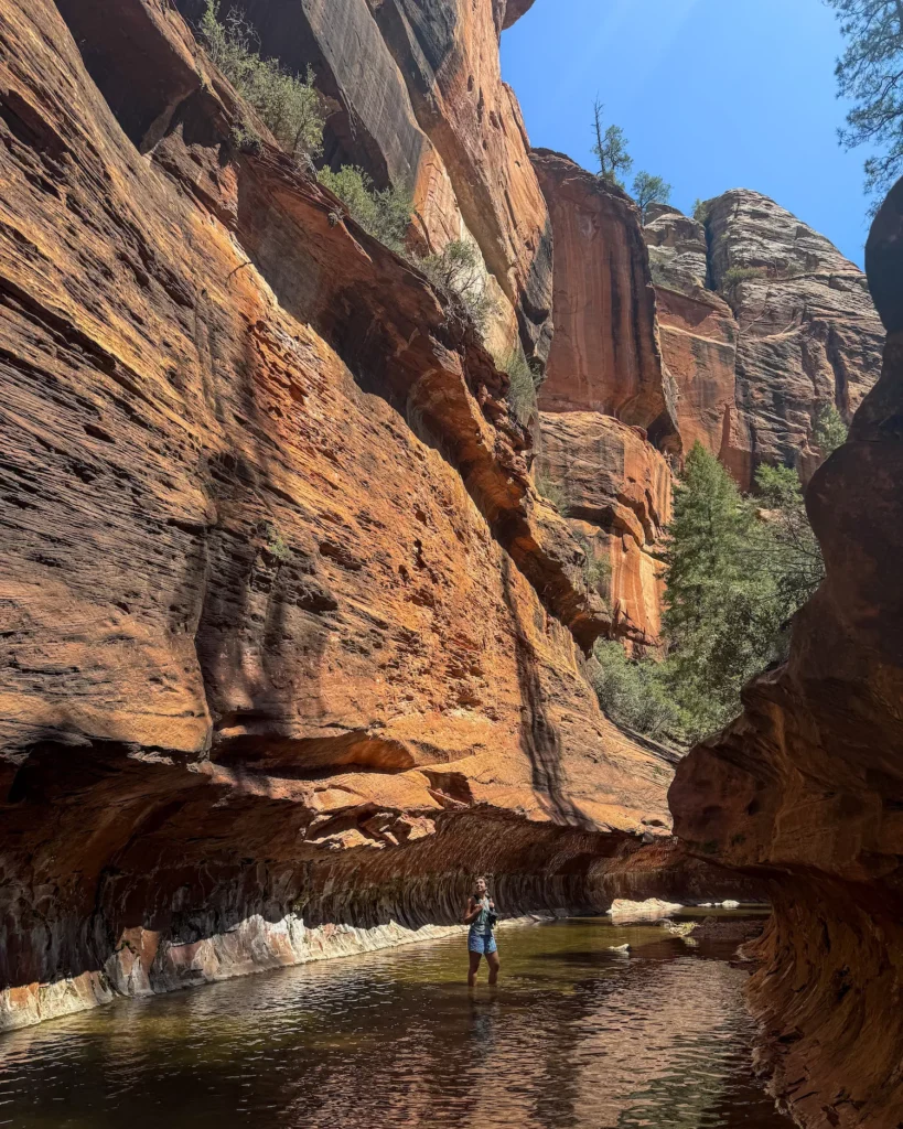 Girl standing in river with canyon on either side