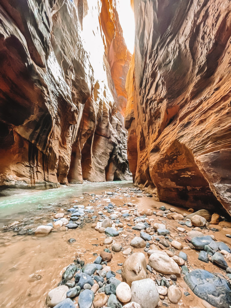The Narrows section with rocks and canyon walls rising up; zion national park itinerary