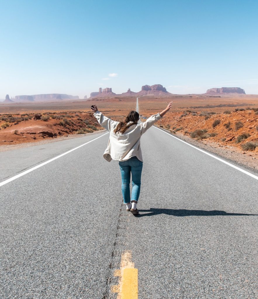 Girl standing at Forrest Gump Point in front of Monument Valley