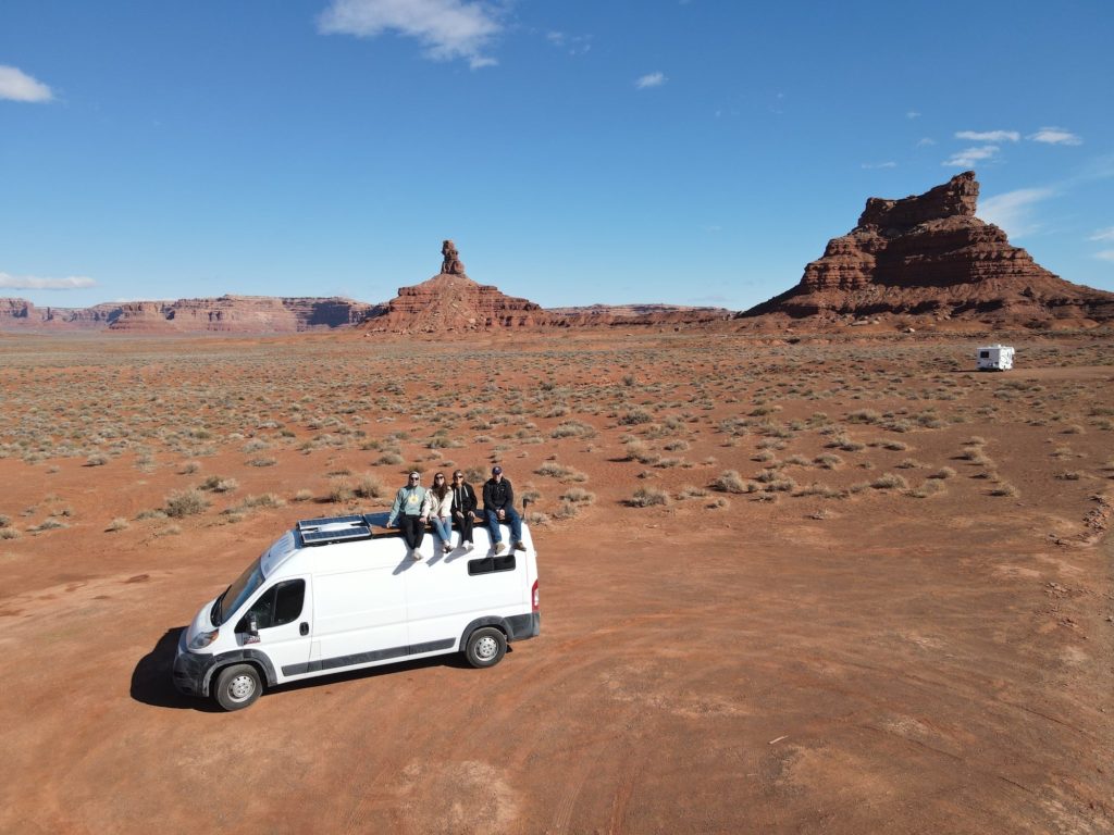 four people sitting on van's roof deck in Valley of the Gods