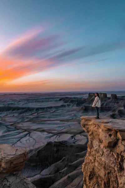 sunrise over moonscape overlook with girl standing there