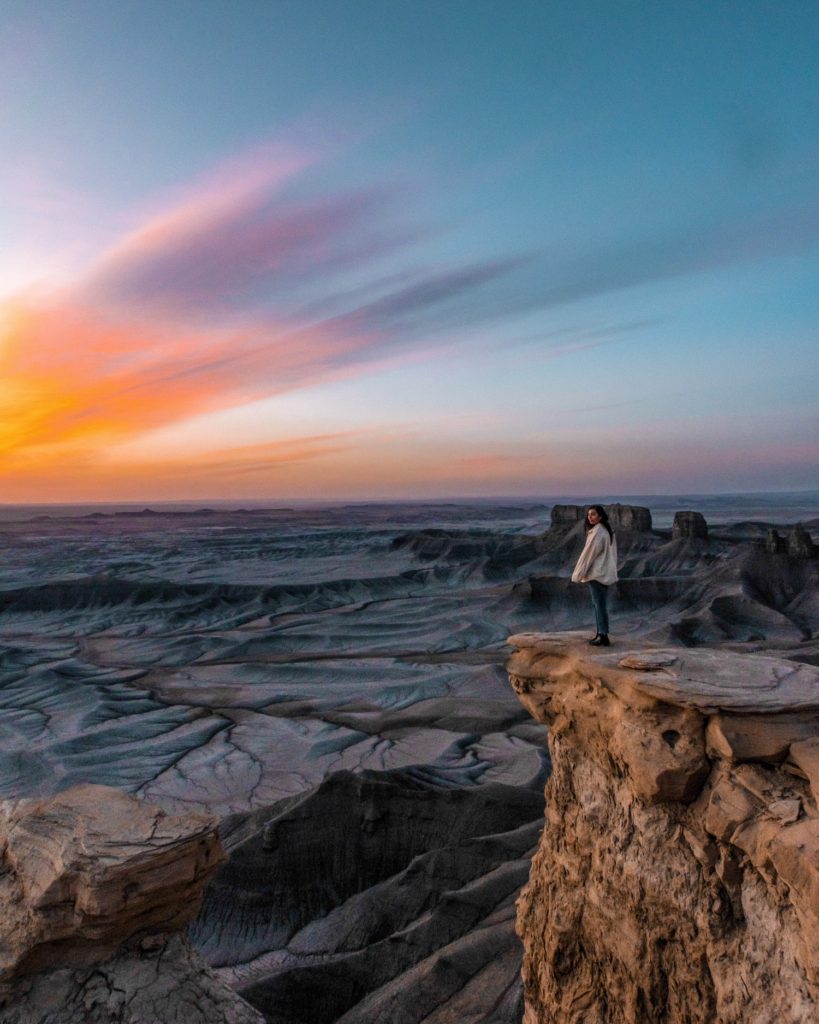 sunrise over moonscape overlook with girl standing there