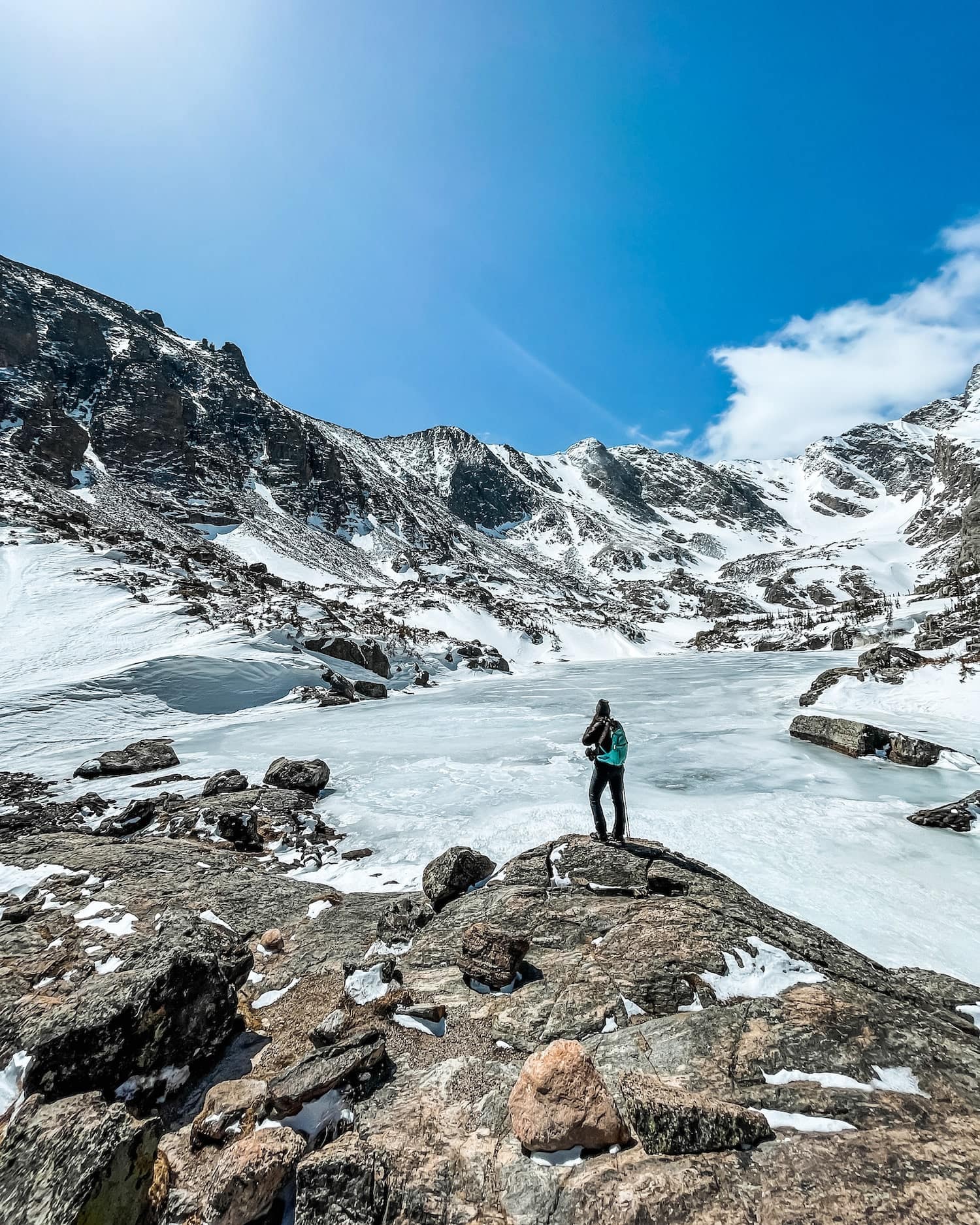 Girl looking out at frozen lake in the rockys