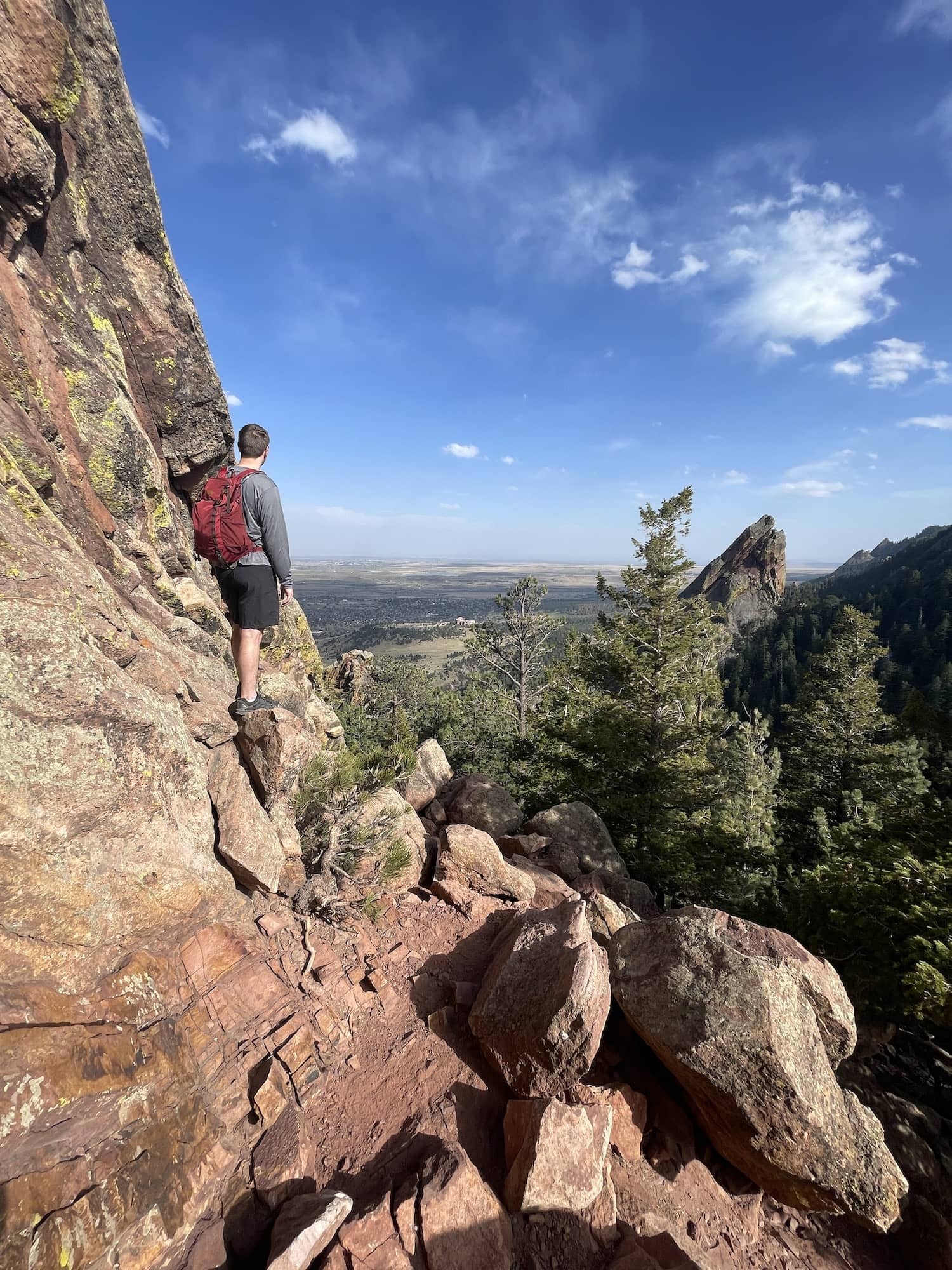 boy standing over boulder