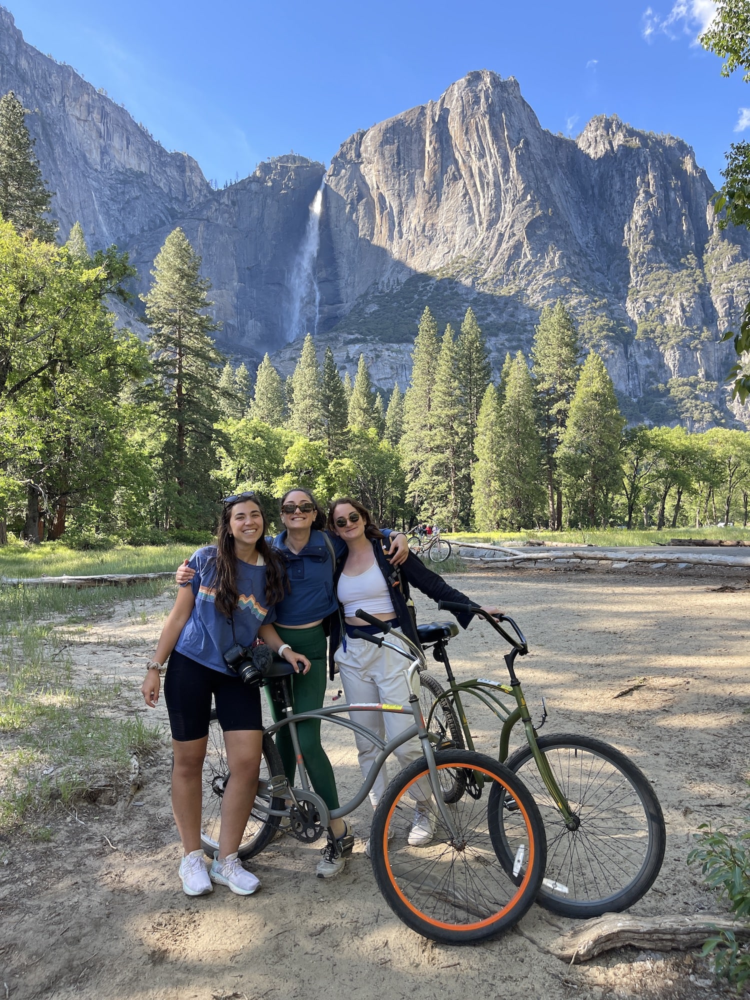 three girls on bikes in yosemite valley in front of yosemite falls