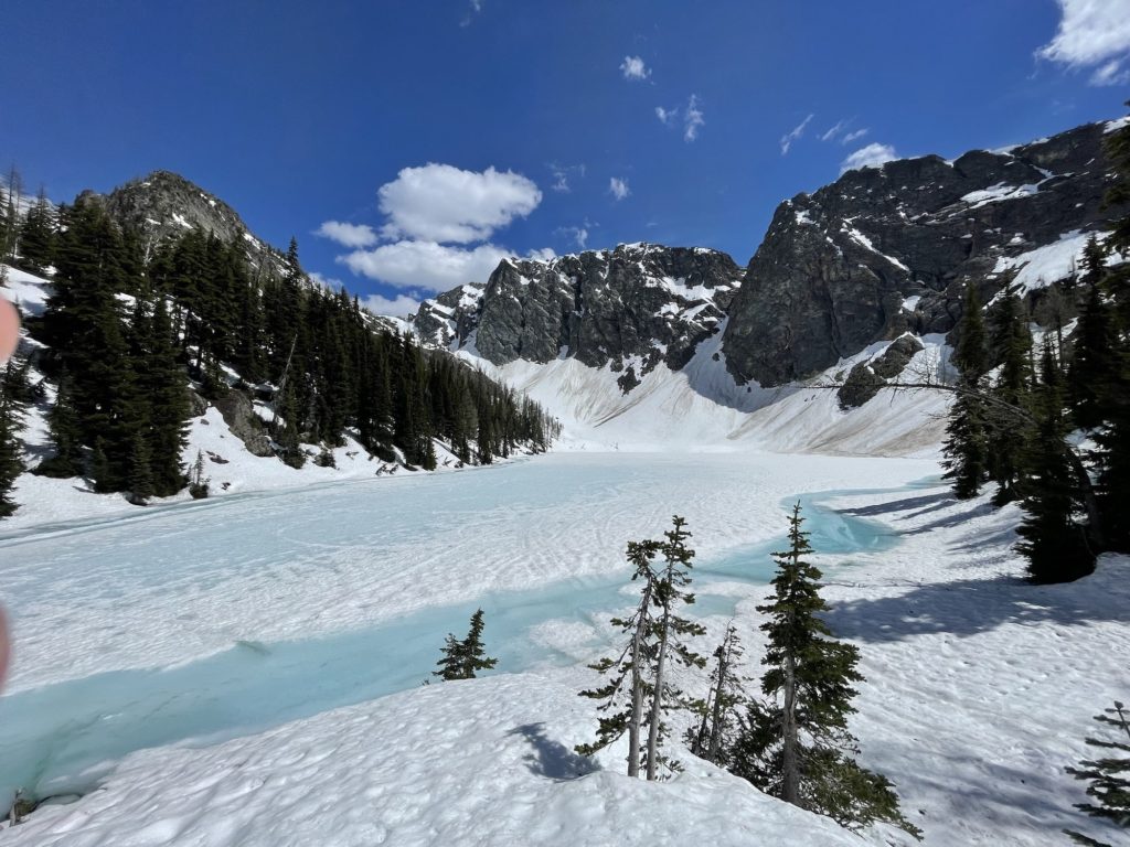 frozen blue lake in north cascades in june