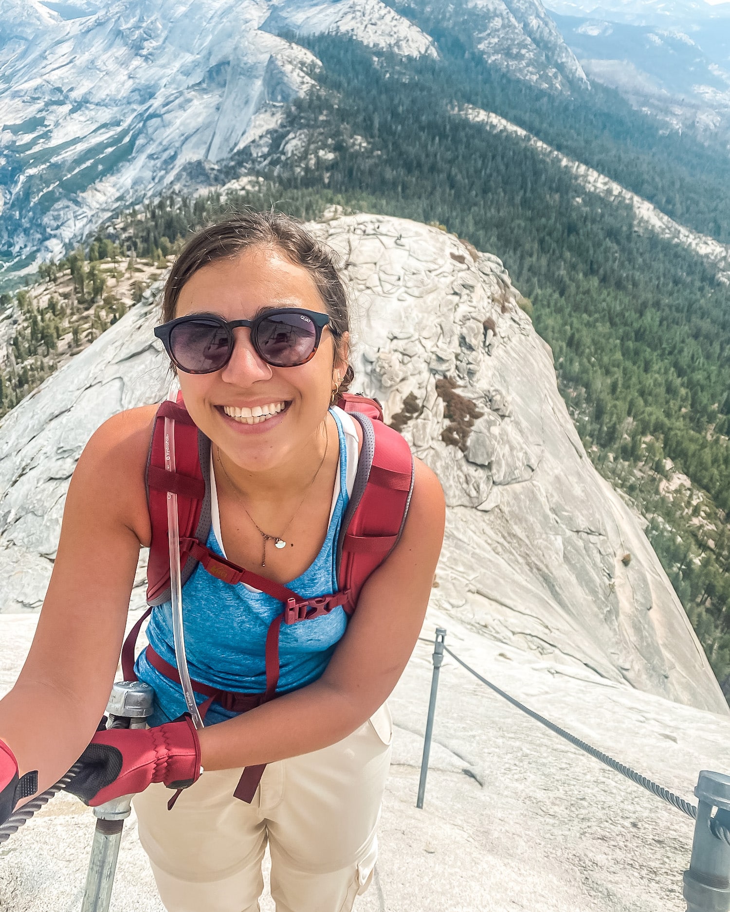 girl climbing the cables of half dome