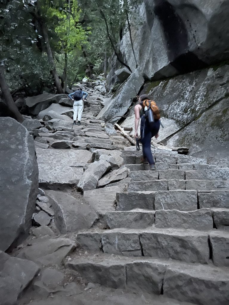 two people climbing up the stairs of half dome/mist trail