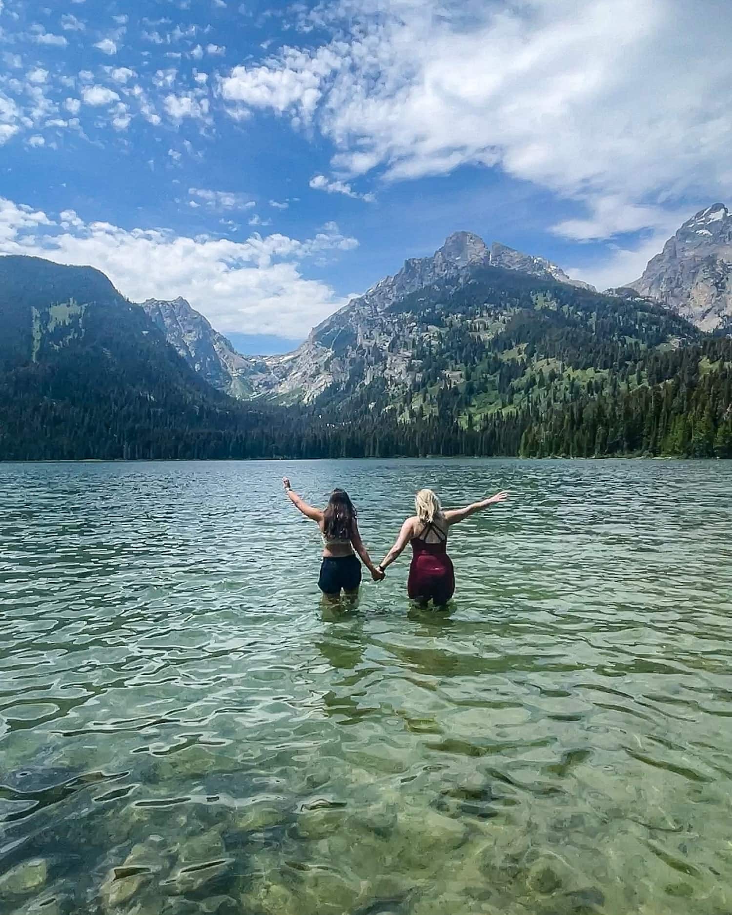 two girls with arms outstretched in taggart lake