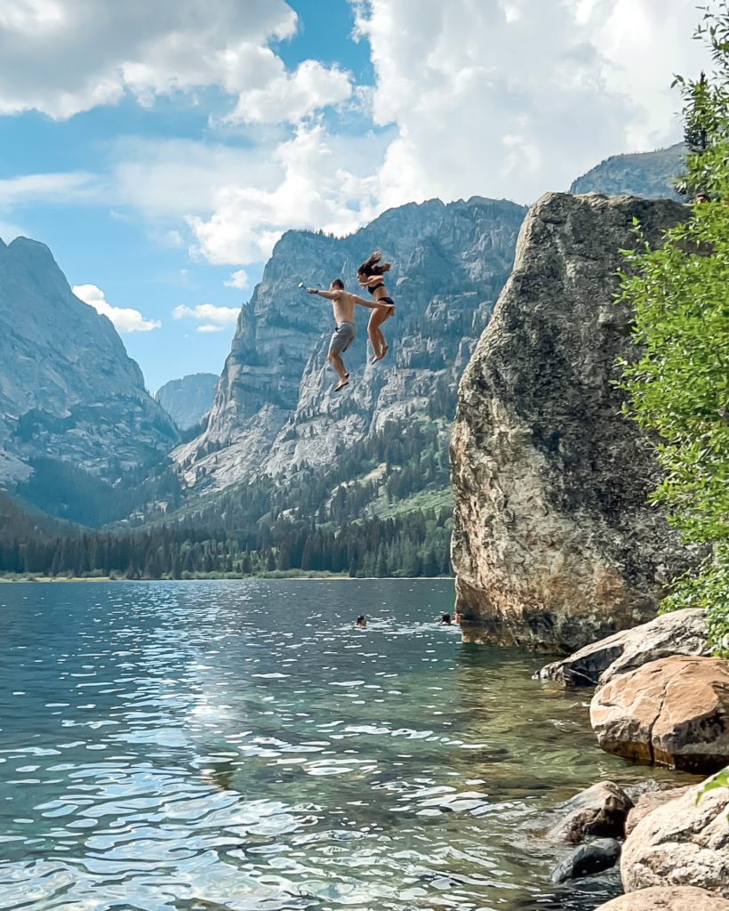 two people jumping into phelps lake