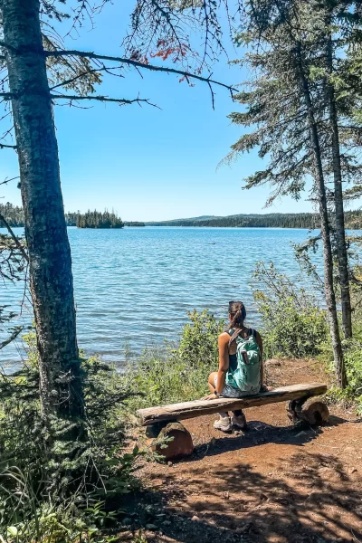 girl sitting looking at blue water of isle royale