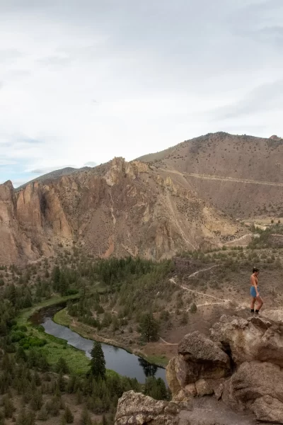 girls standing on rock formation at misery ridge trail, Crooked River and Mountains behind her