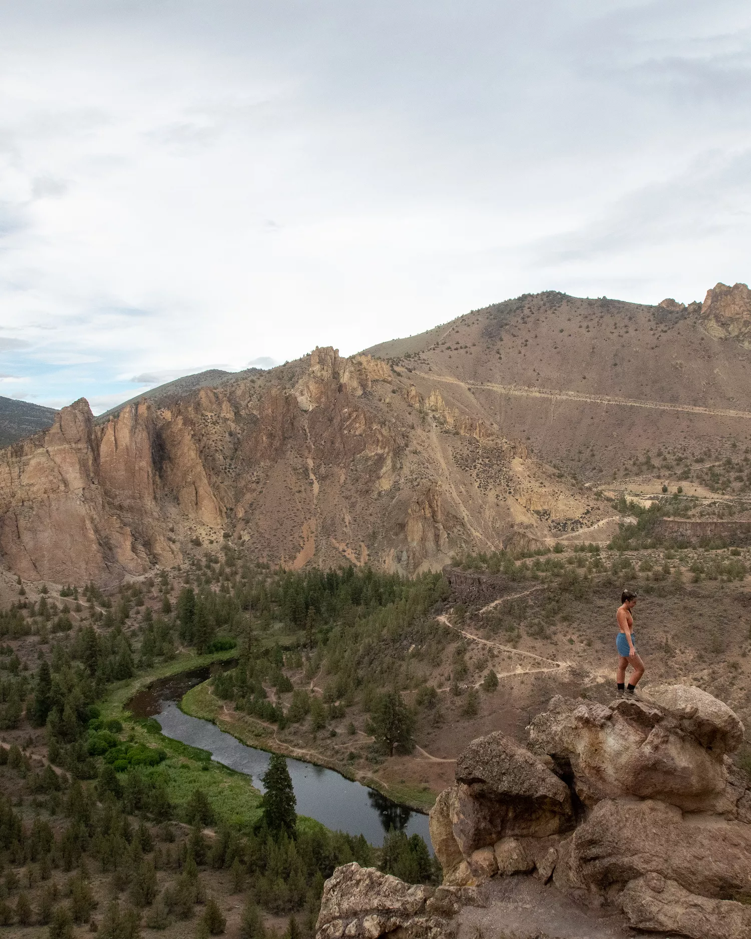 girls standing on rock formation at misery ridge trail, Crooked River and Mountains behind her