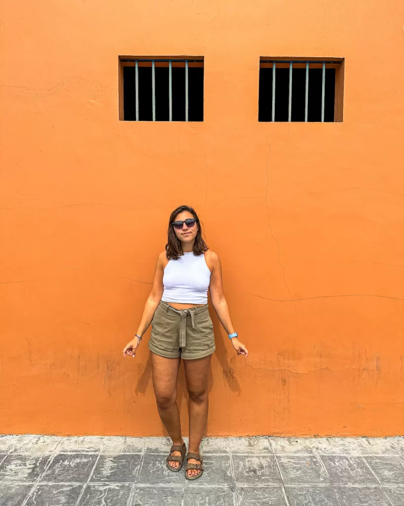 girl in front of orange wall in todos santos