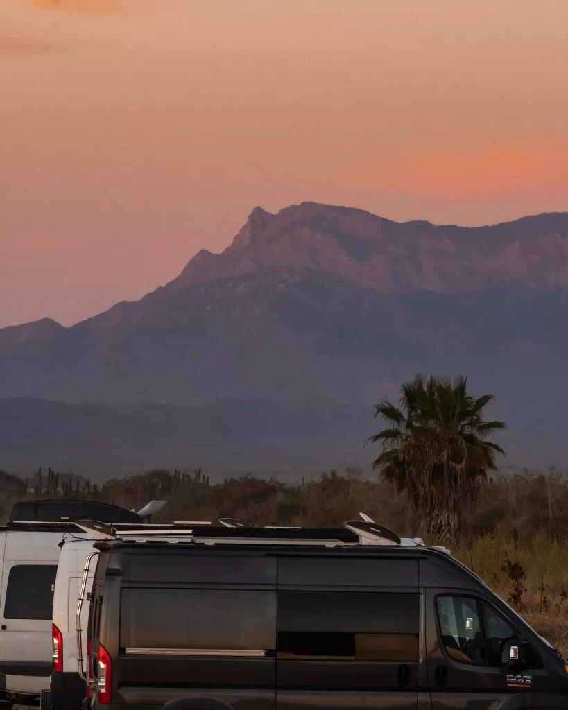 vans parked at sunset with mountains behind and starlink on their vans