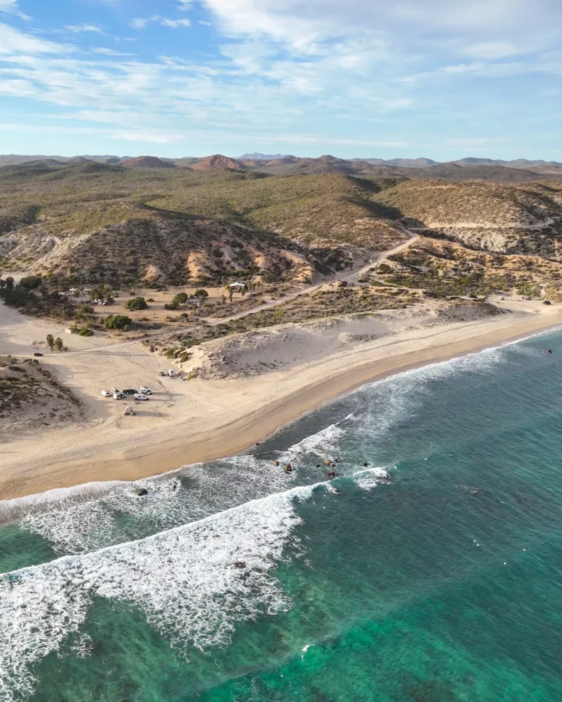 Three vans in a cove with beach around it