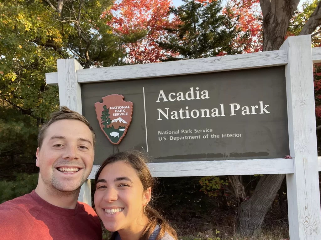 two people taking selfie in front acadia national park sign