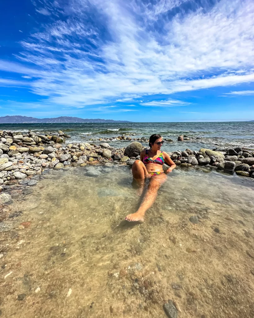 girl sitting in hot springs of playa agua caliente