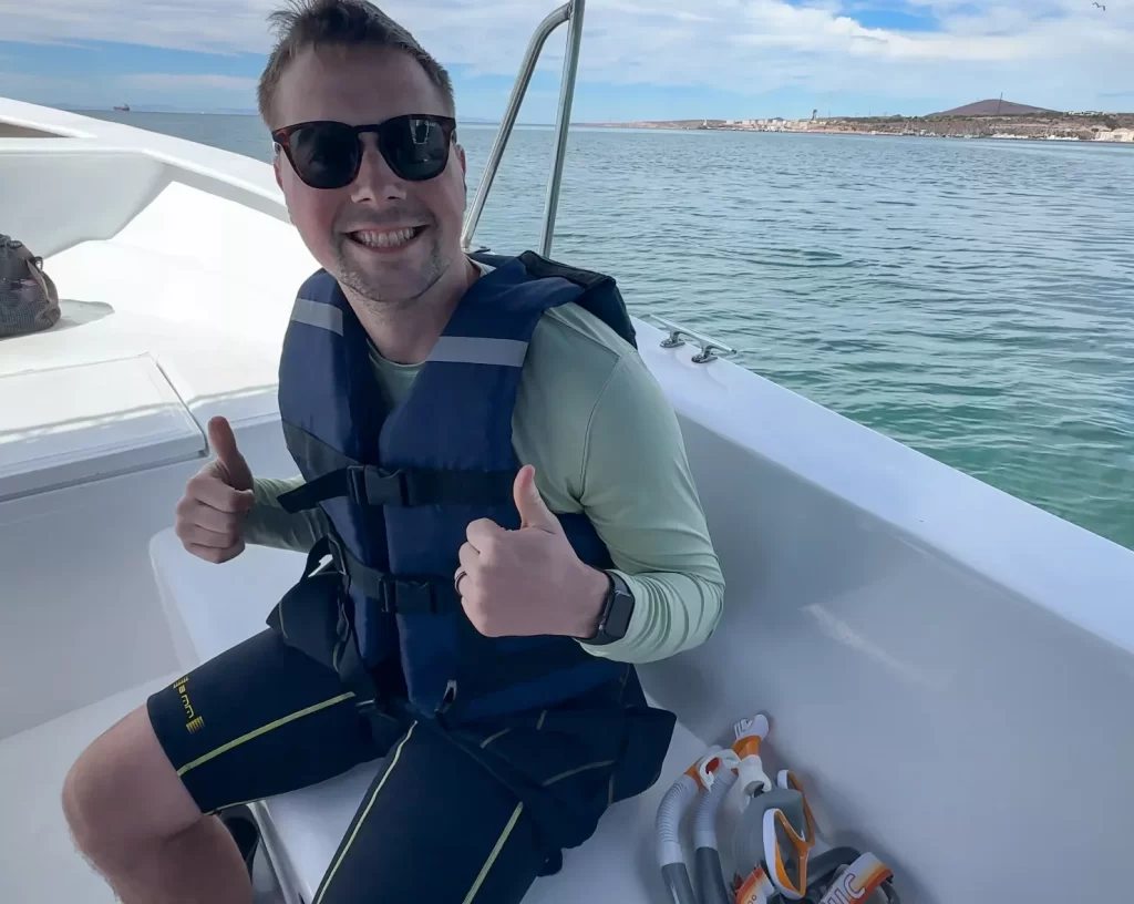 boy with two thumbs up on a boat