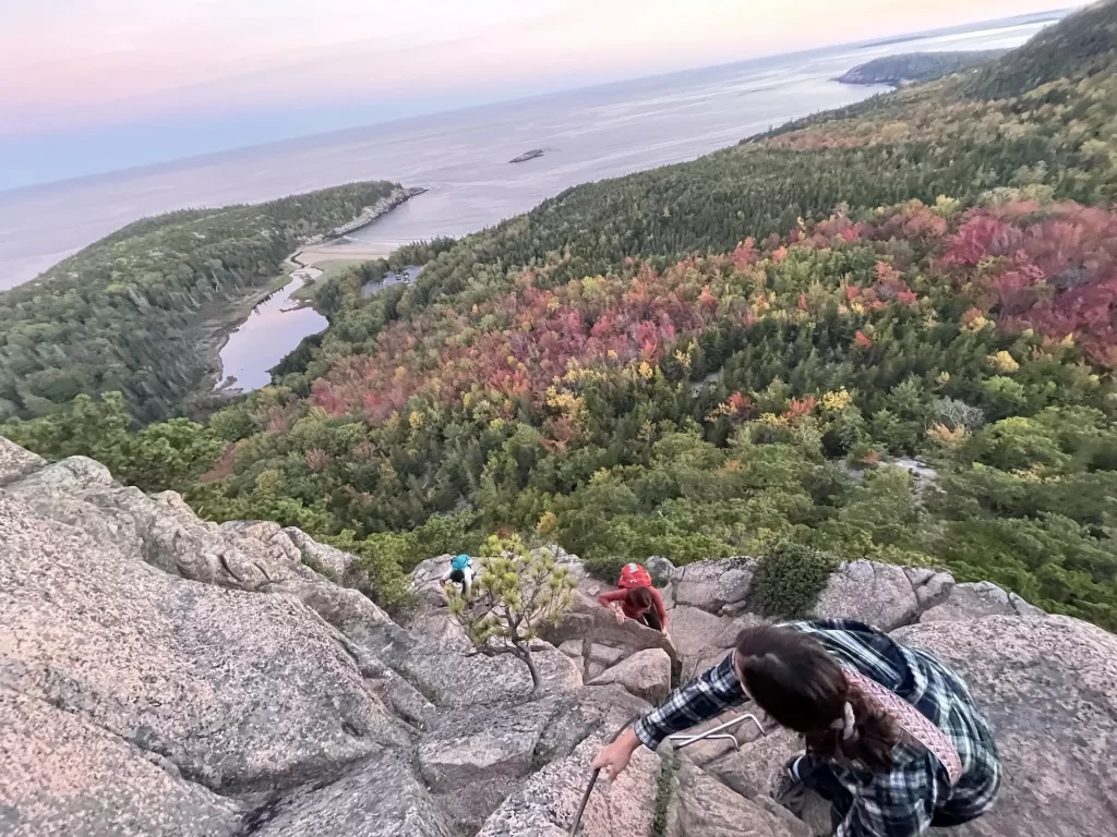 people climbing up the rungs on beehive trail in acadia